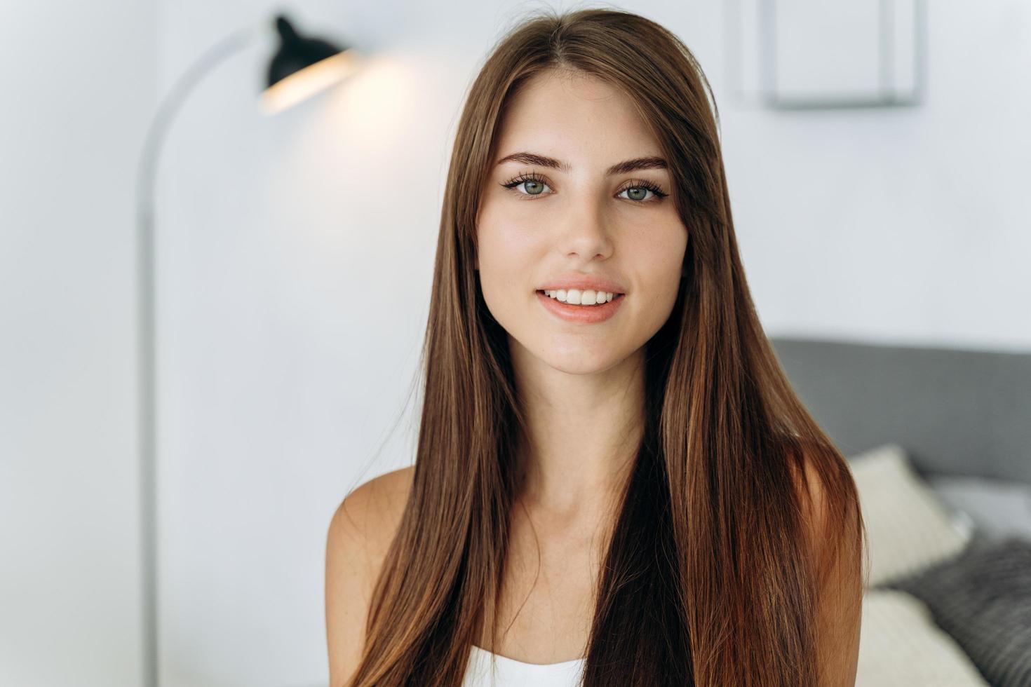 Retrato de mujer joven sonriendo mientras posa en sus acogedores apartamentos foto