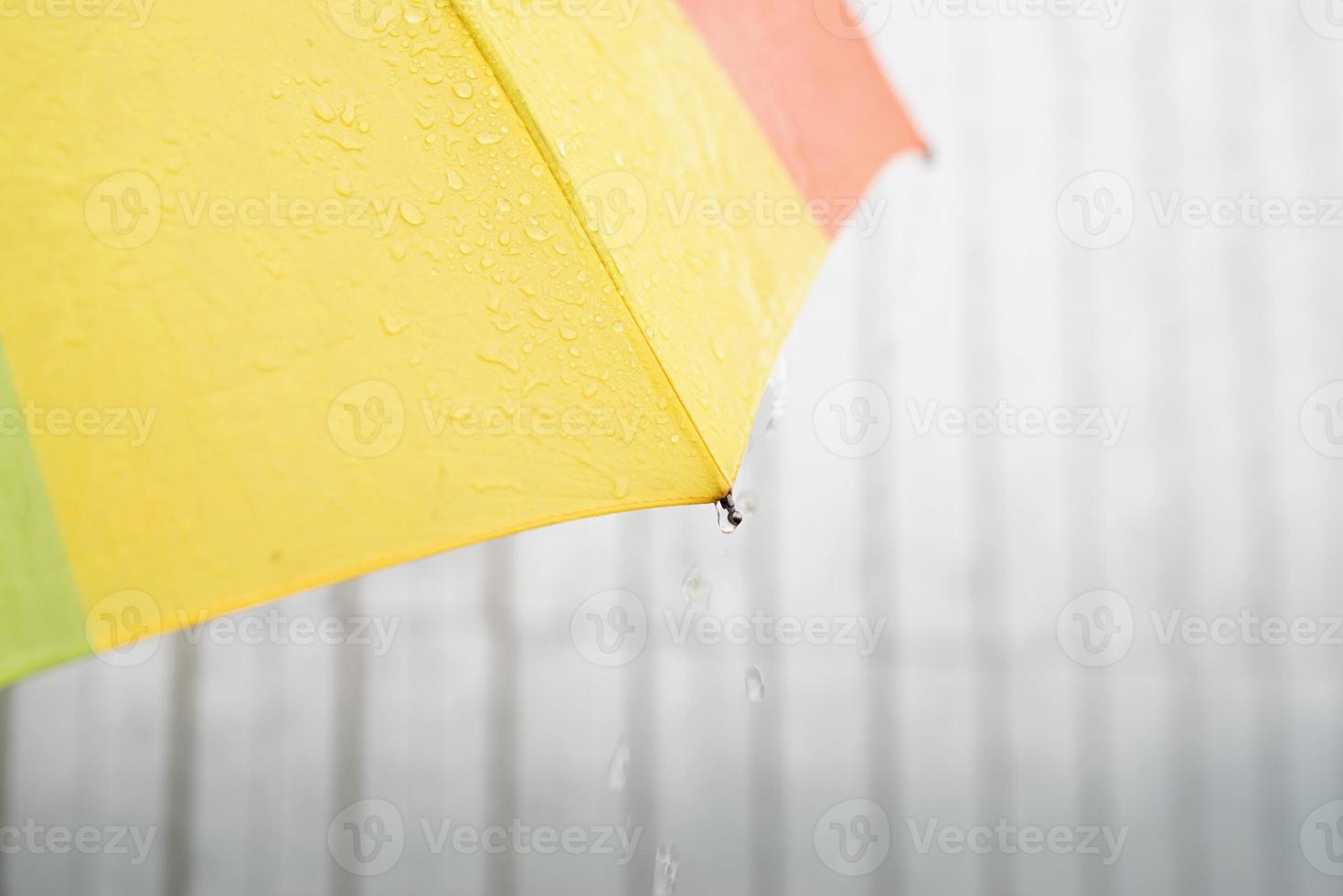 Cerca de la colorida parte del paraguas con gotas de lluvia foto