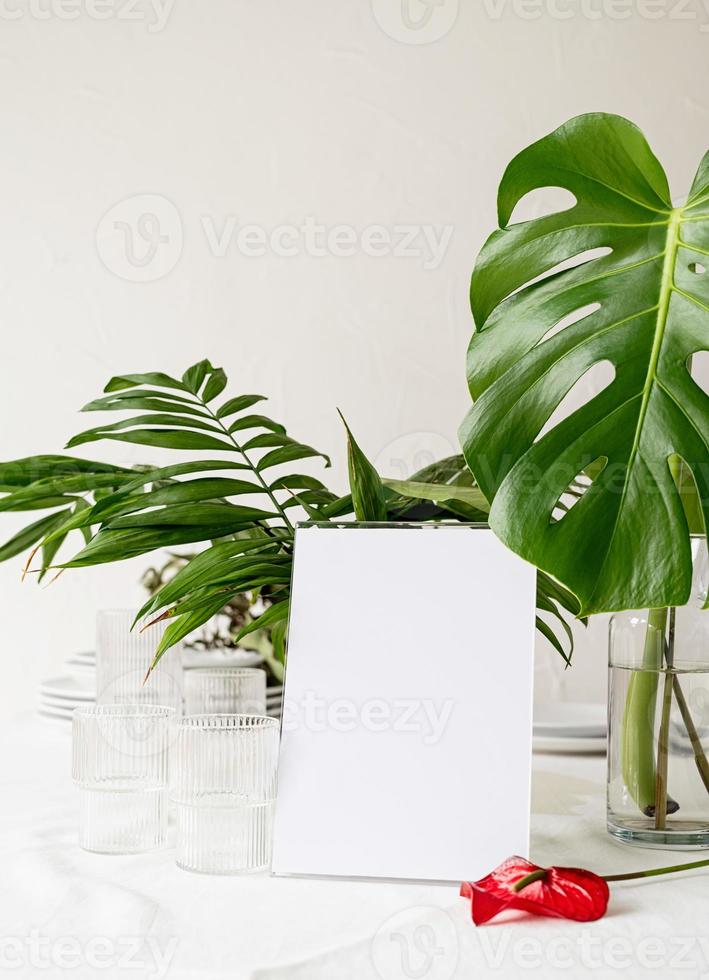 Menu or stand for booklet on restaurant table with tropical bouquet photo