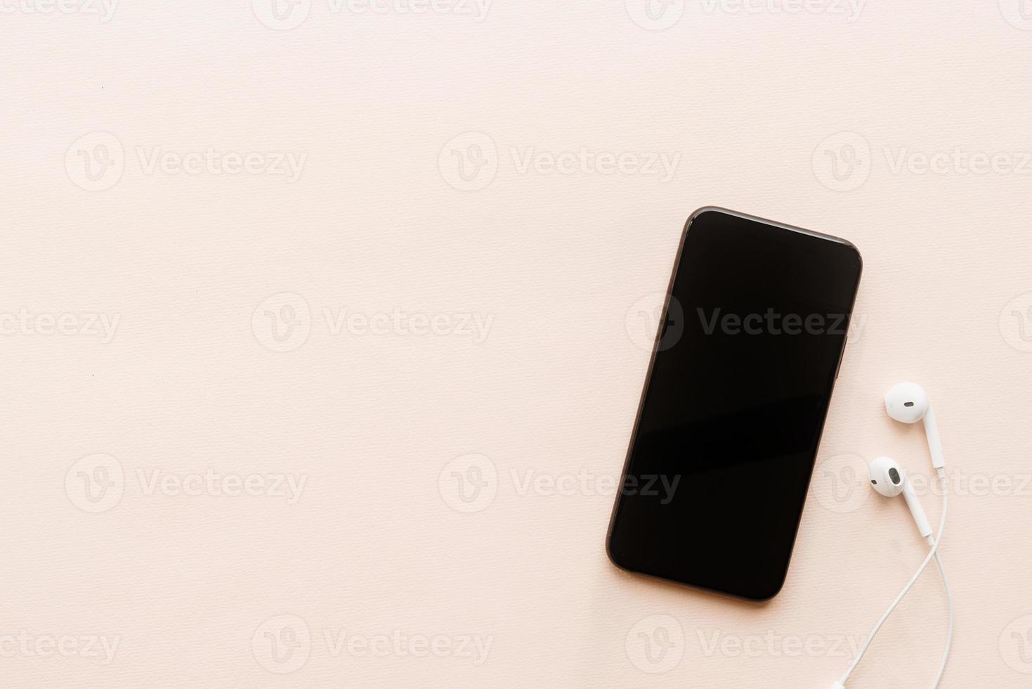 Top view of smartphone with blank screen headphones, copy space photo