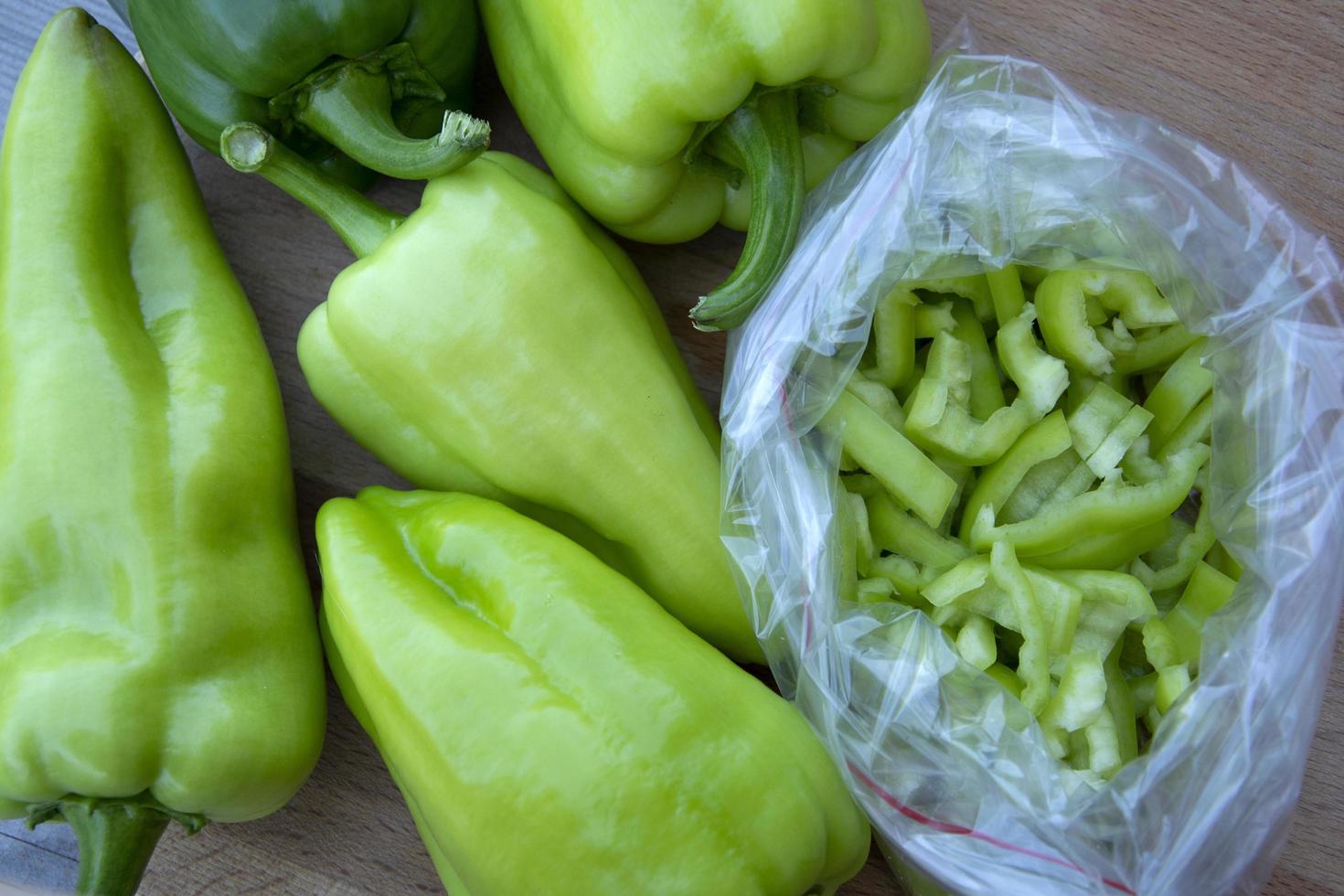 una bolsa de pimientos morrones, cortados en tiras para congelar, de cerca foto