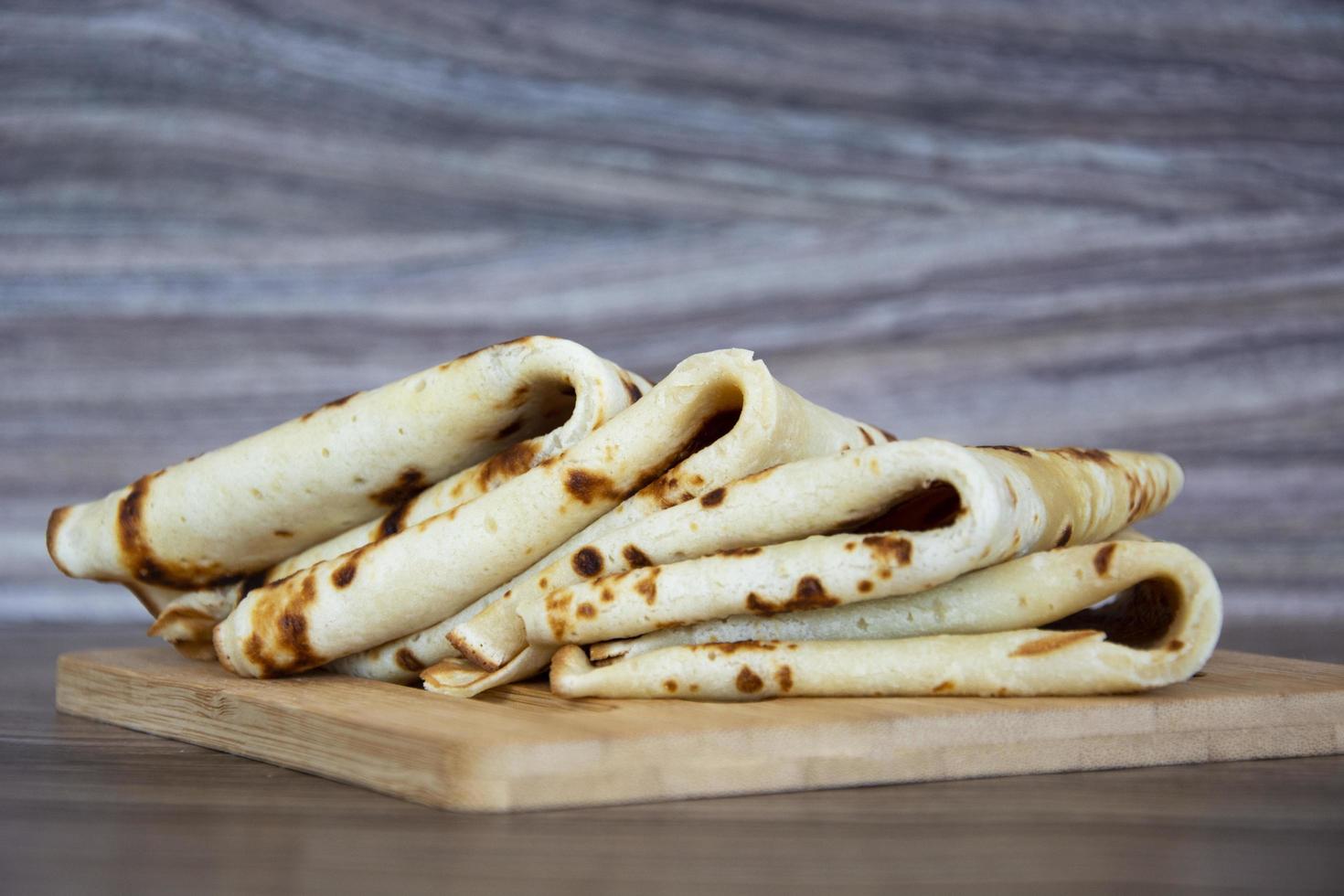 Pancakes stacked in a stack on a wooden background photo