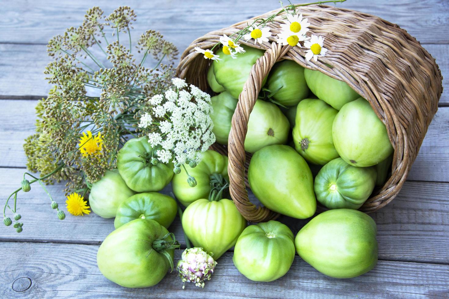 Verduras en una canasta de mimbre sobre un fondo de madera foto