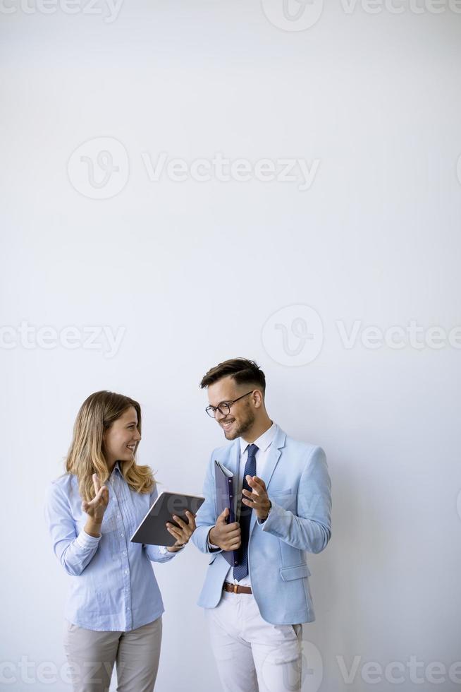 jóvenes empresarios con tableta junto a la pared en la oficina foto