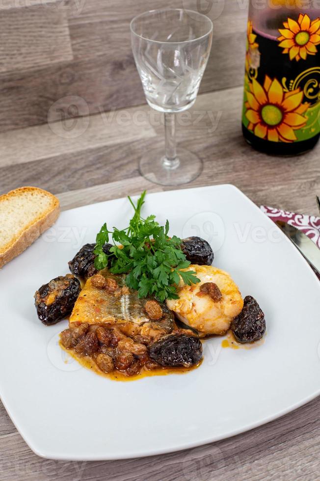 Composición en la mesa de un plato de bacalao agridulce foto