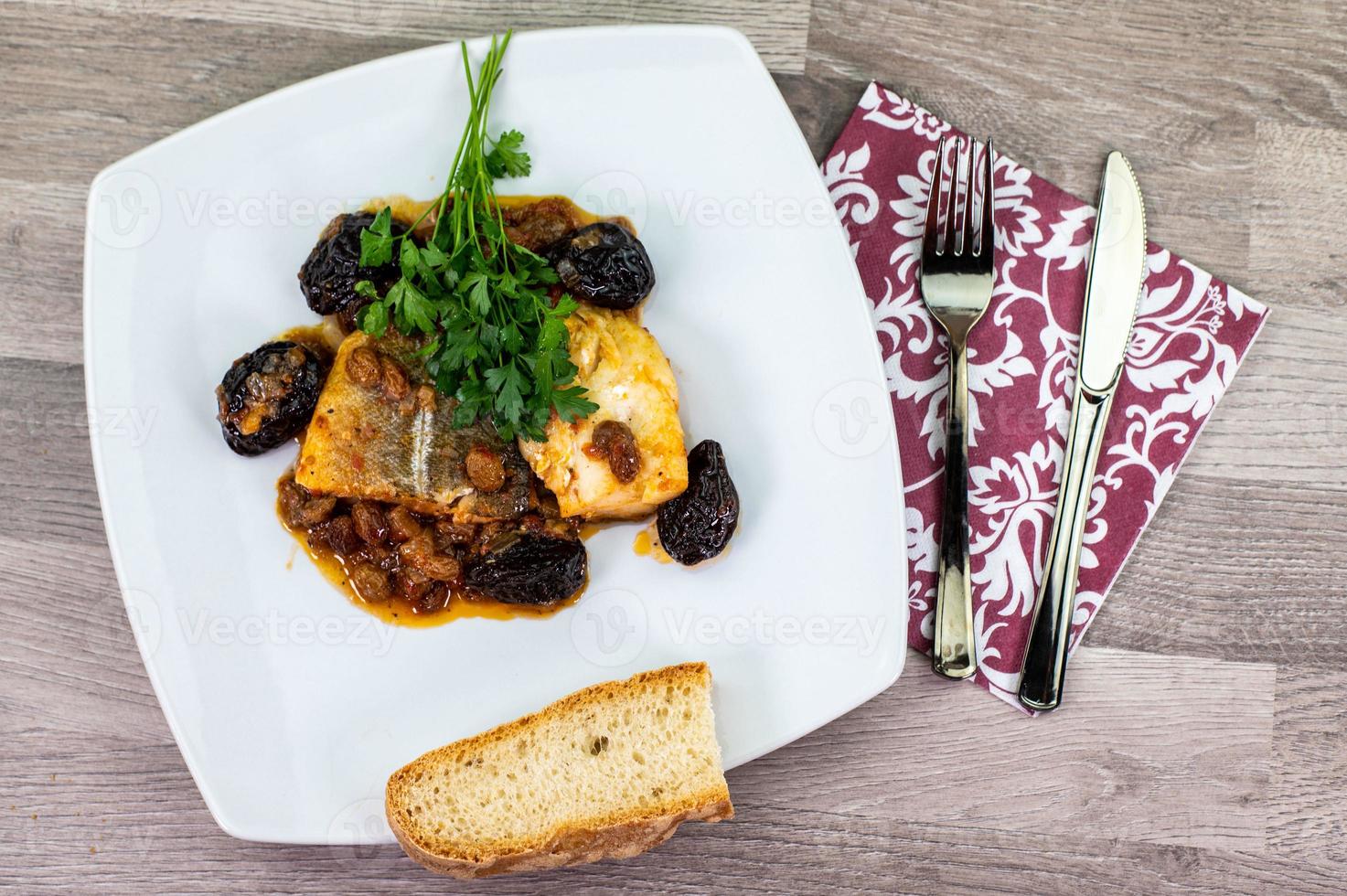 Composición en la mesa de un plato de bacalao agridulce foto