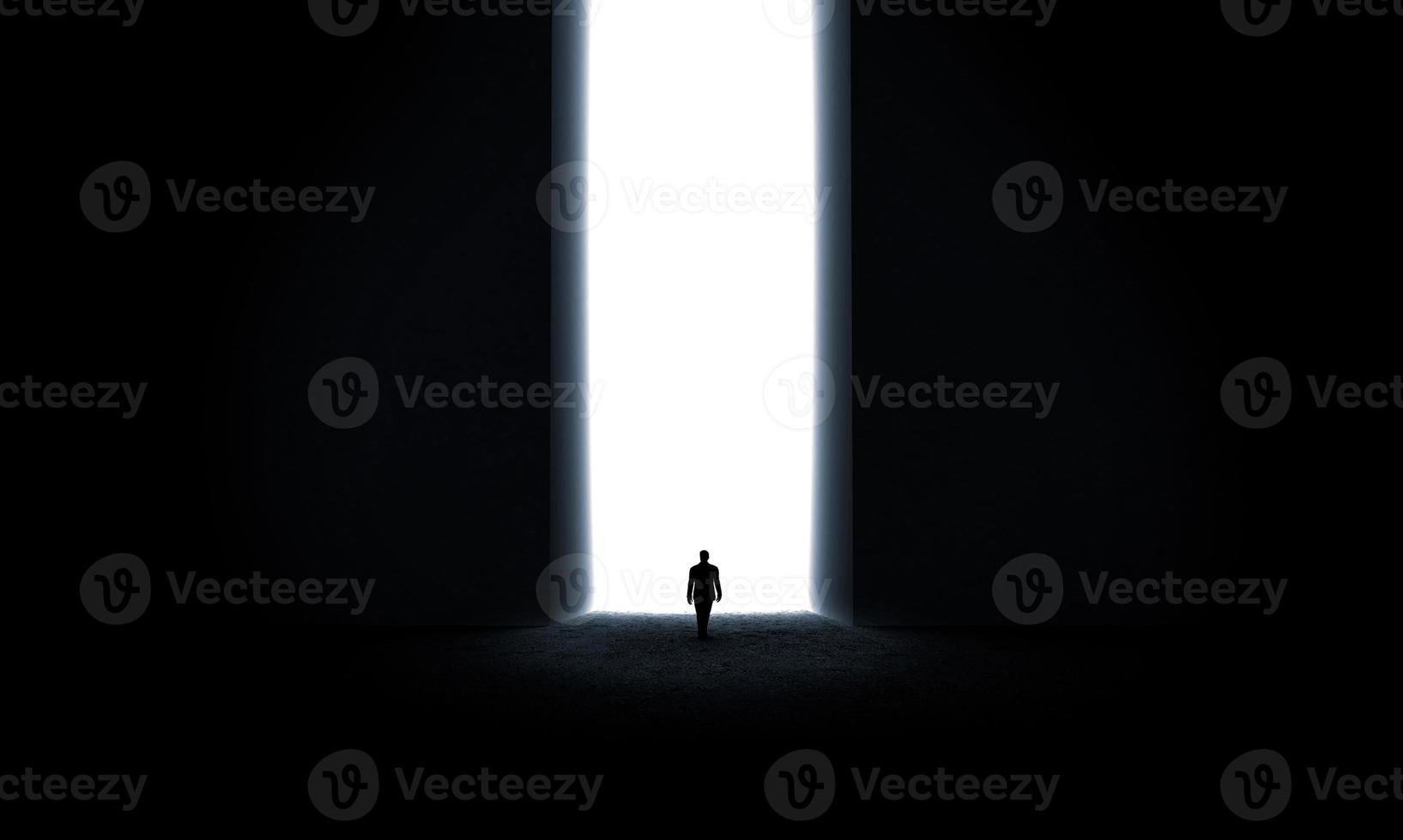 Silhouette of businessman standing in front of lighting door photo