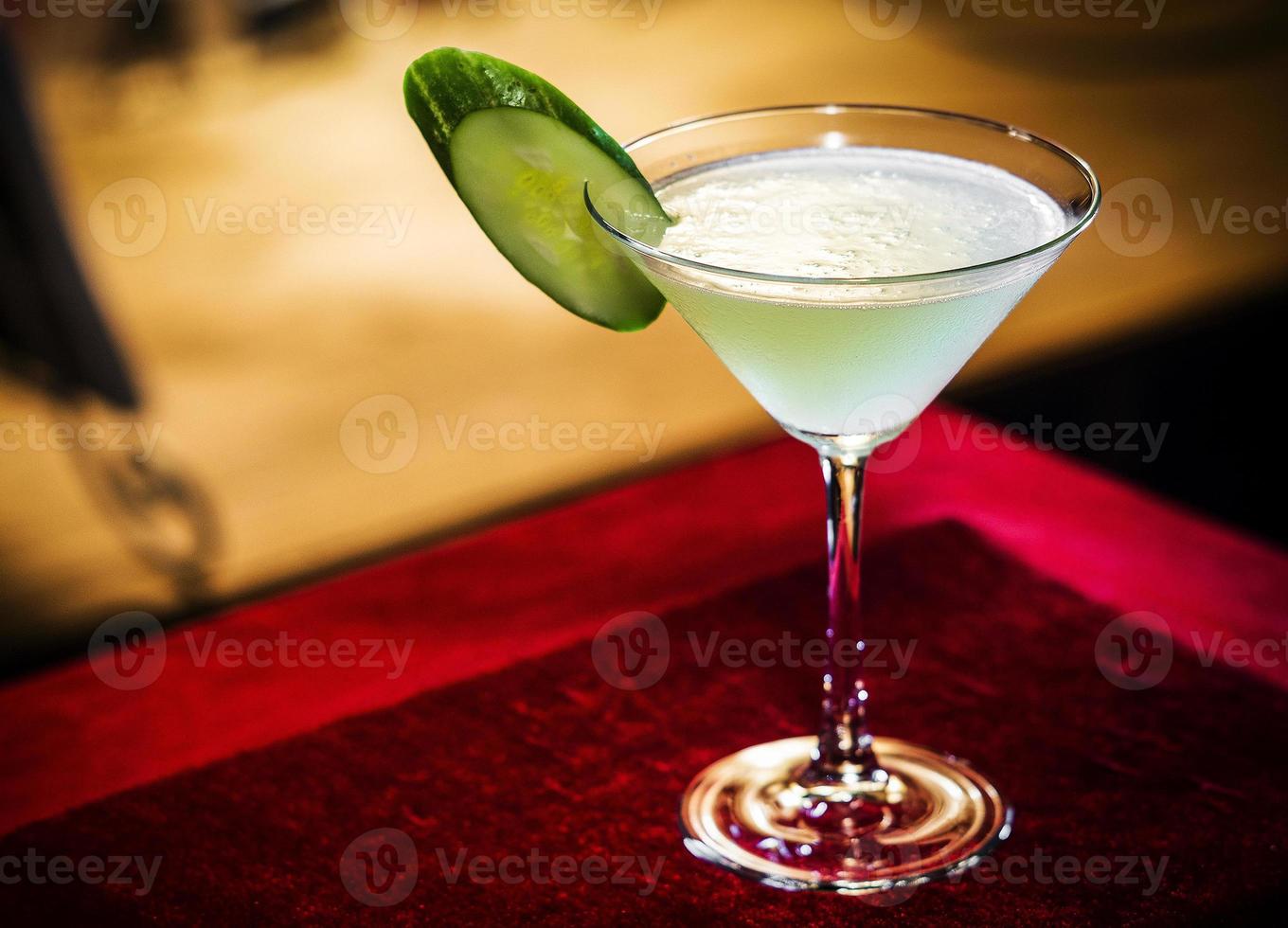 Cucumber and lime martini mixed cocktail drink glass inside cozy bar photo