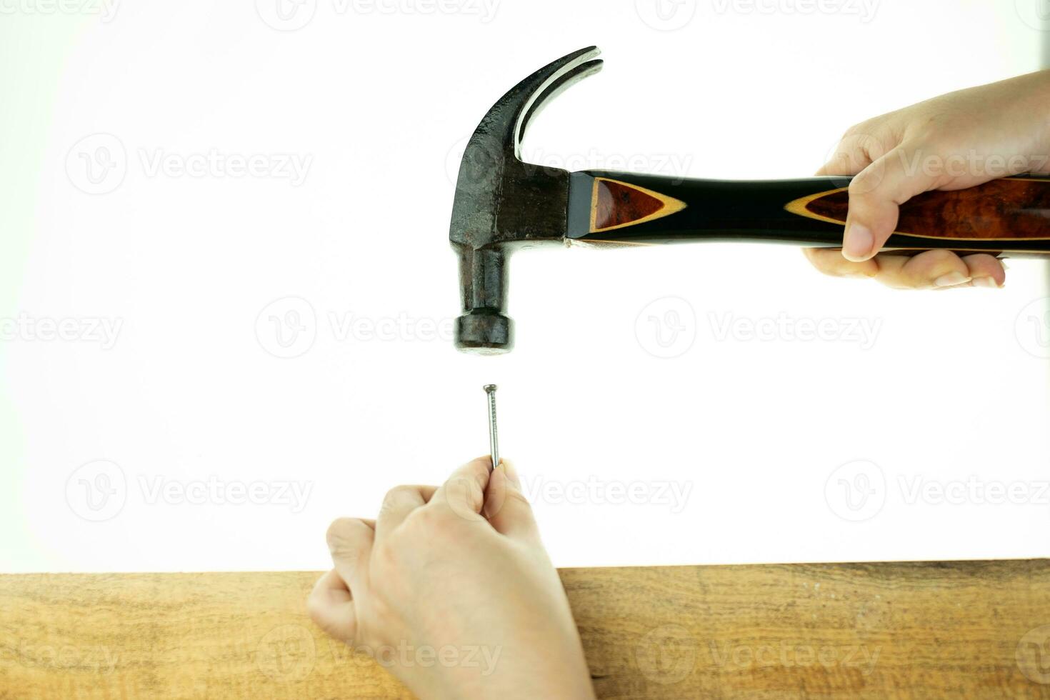 Hand hoiding hammer hitting a nail photo