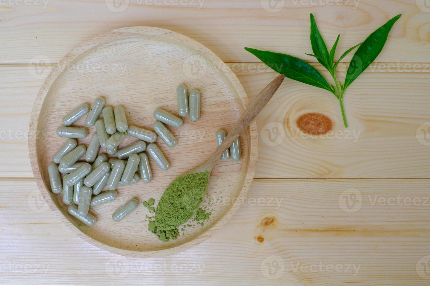 Kariyat  powder in wooden spoon with herbal capsules photo