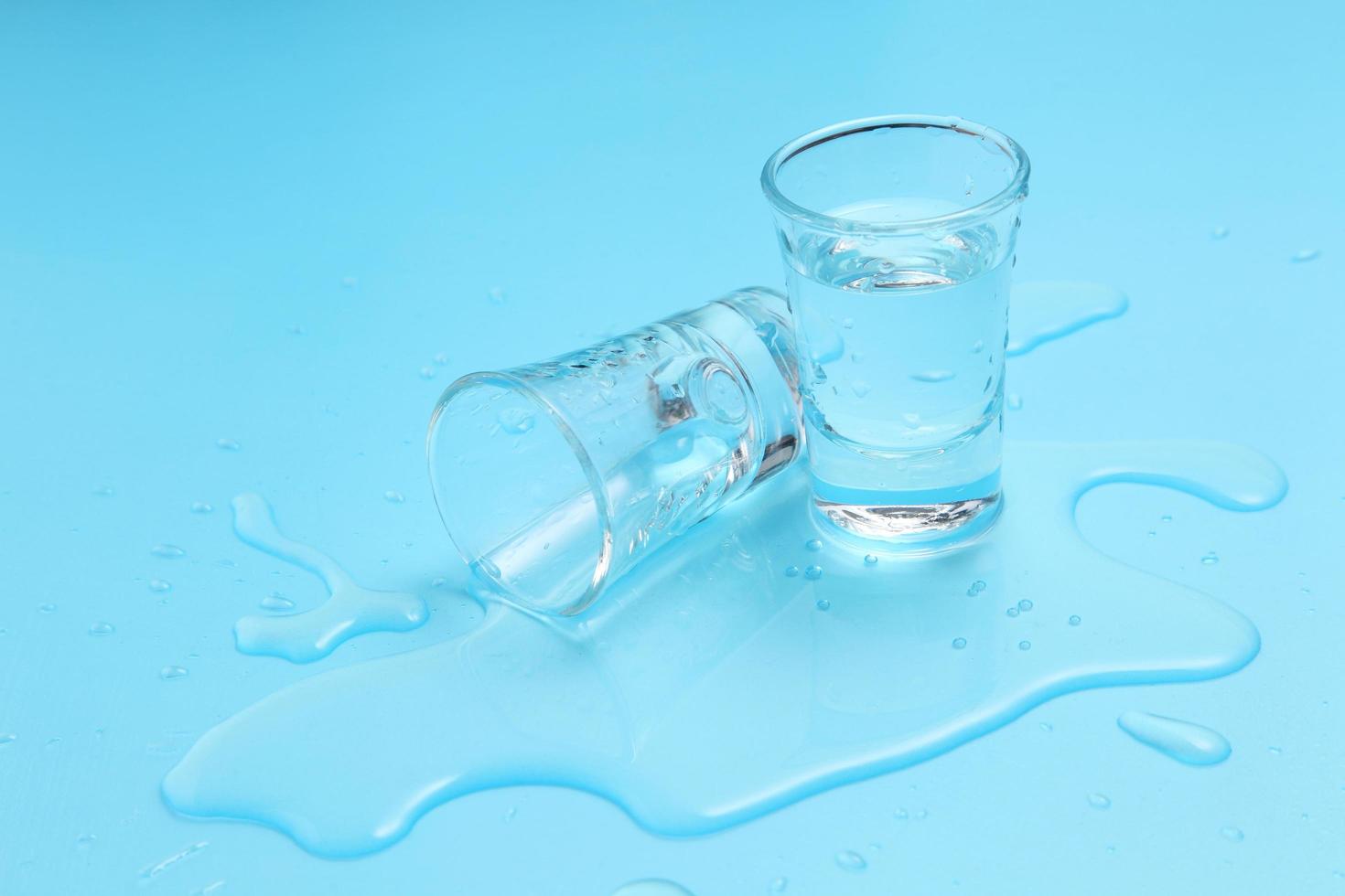 Vodka en vaso de chupito sobre fondo azul. foto