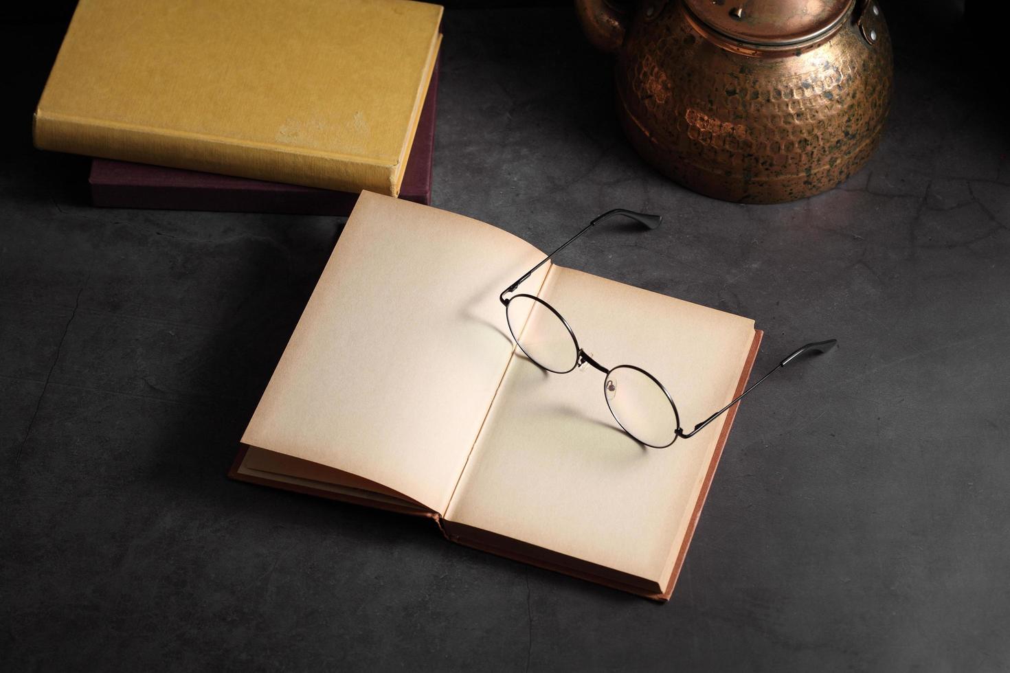 Old books and glasses open on table in library photo