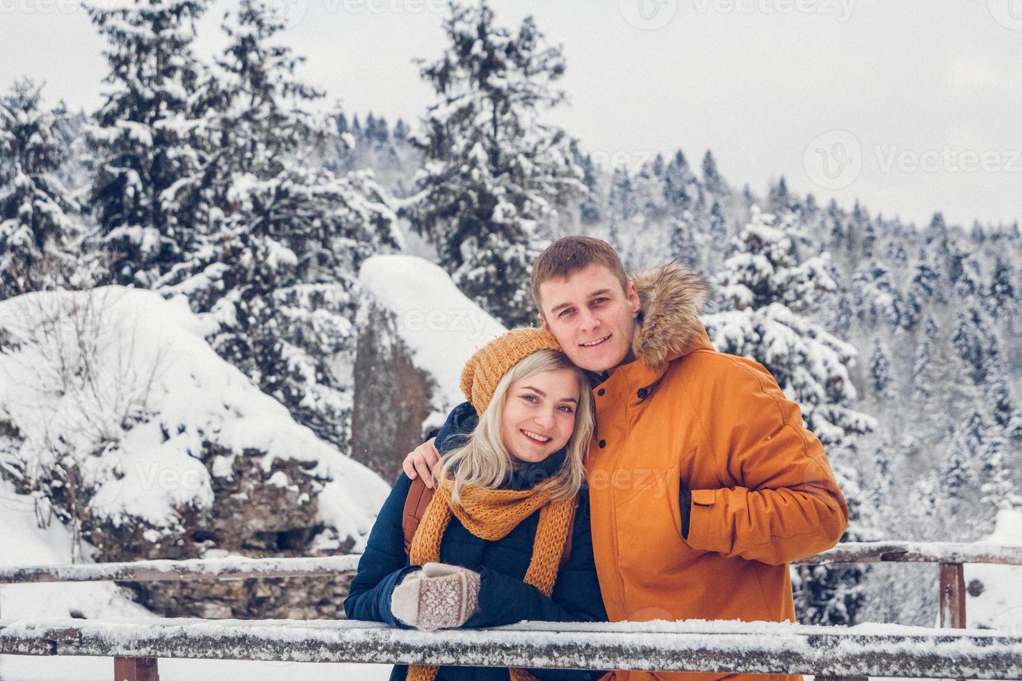 Happy loving couple walking in winter park enjoying snow photo