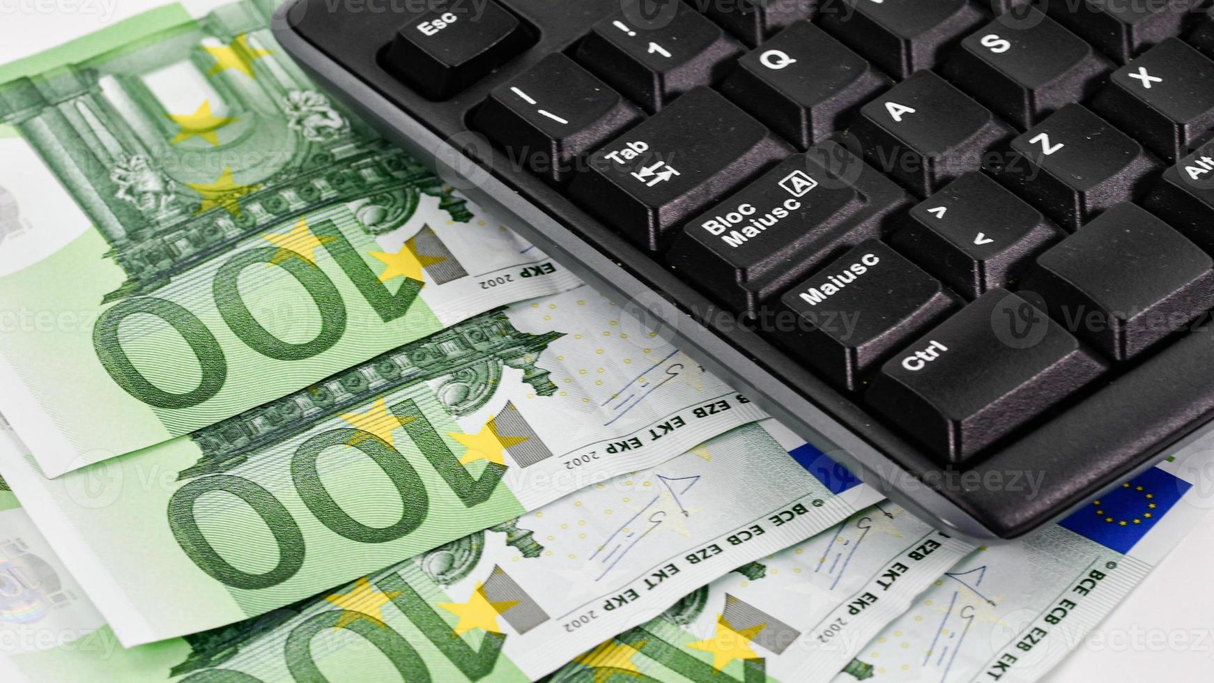 detail of a computer keyboard and 100 euro bills photo