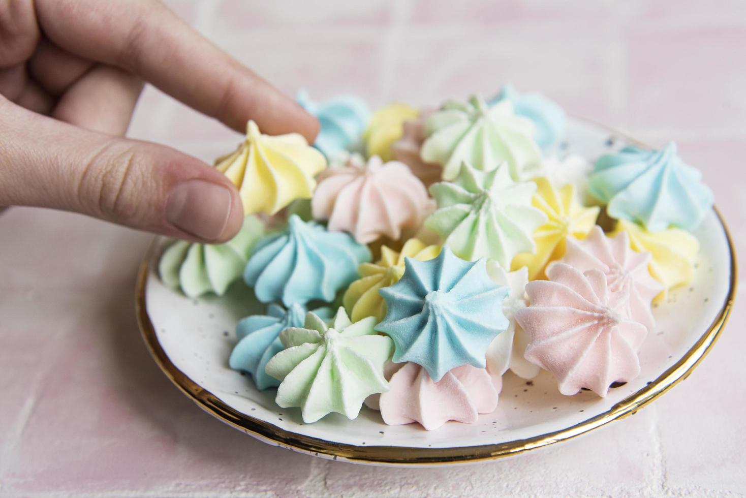 pequeños merengues de colores en el plato de cerámica foto