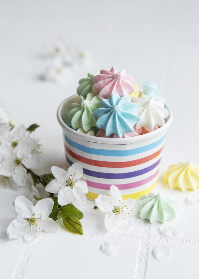 Small colorful meringues in the  paper bowl photo