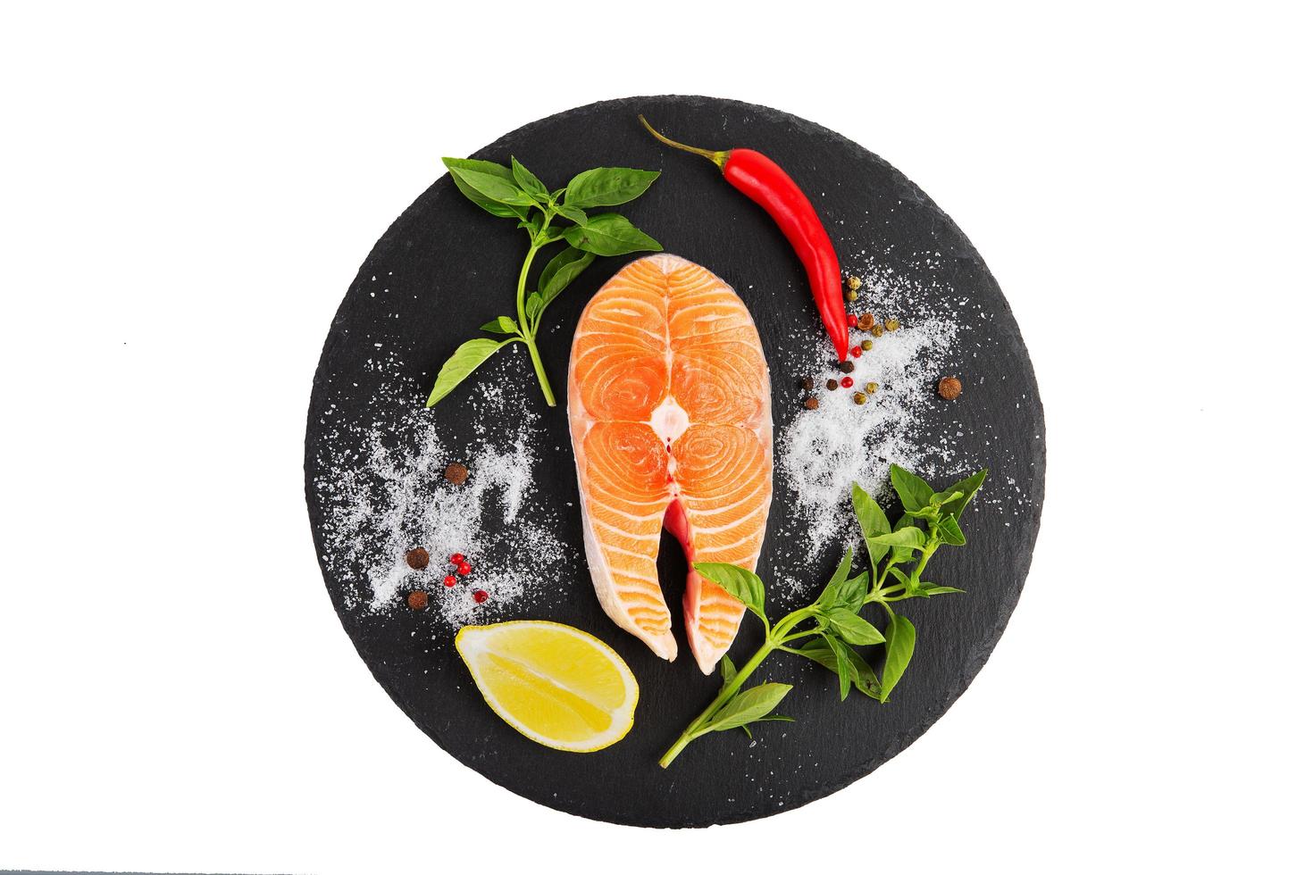 Fresh salmon steak with lemon, tomato, olive oil and basil photo