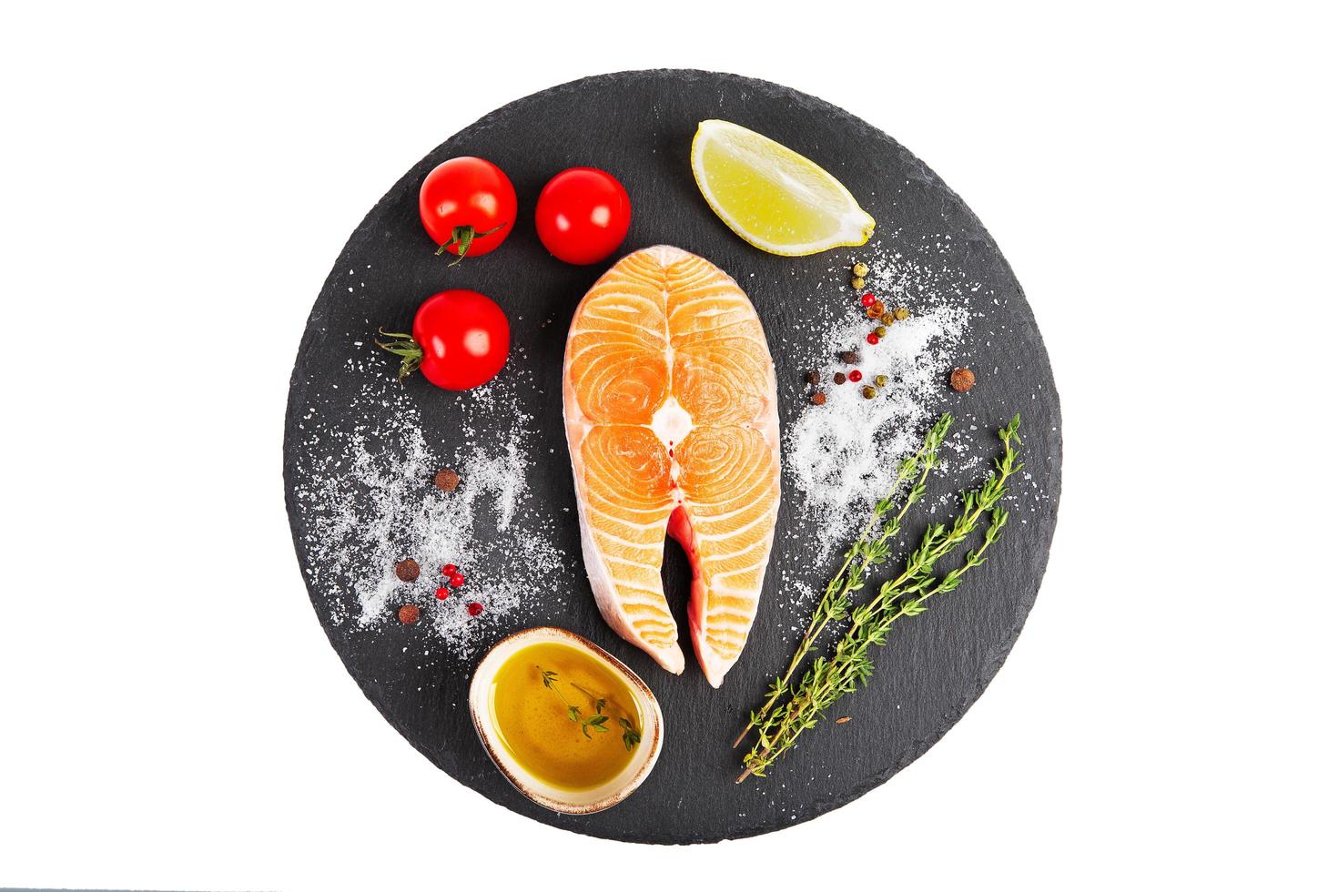 Fresh salmon steak with lemon, tomato and olive oil photo