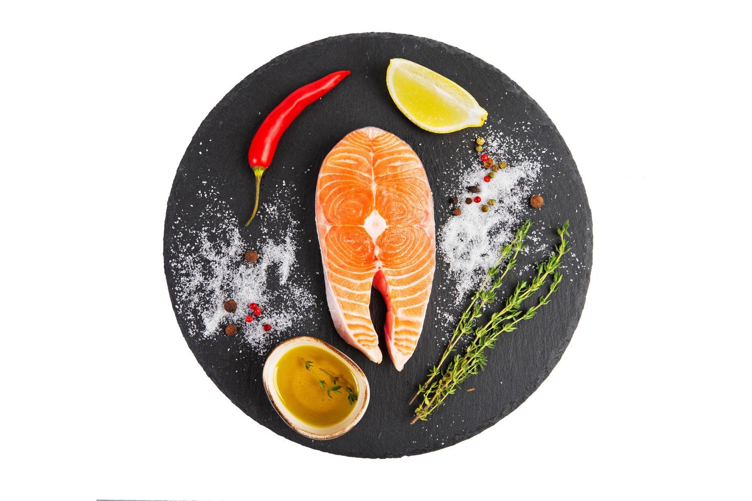 Fresh salmon steak with lemon, pepper and olive oil photo