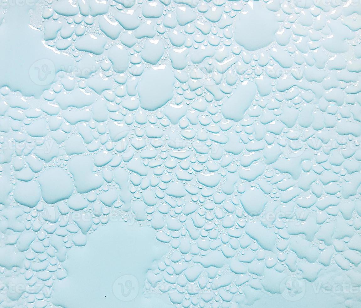 Abstract water droplets sparkling on light blue background photo