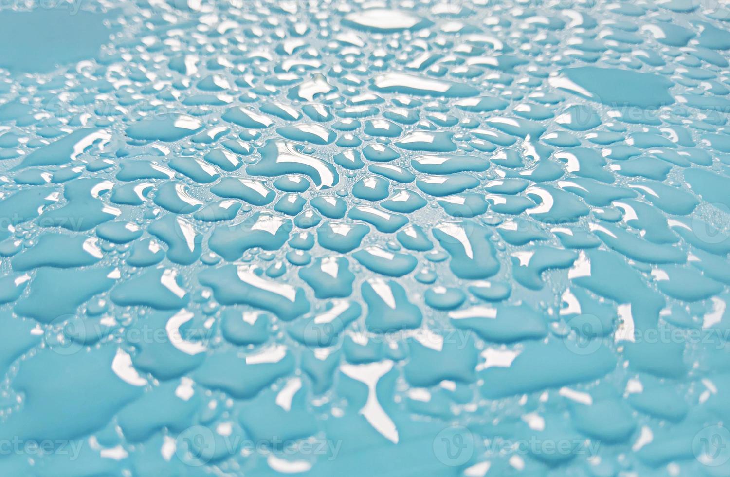 Abstract water droplets sparkling on light blue background photo