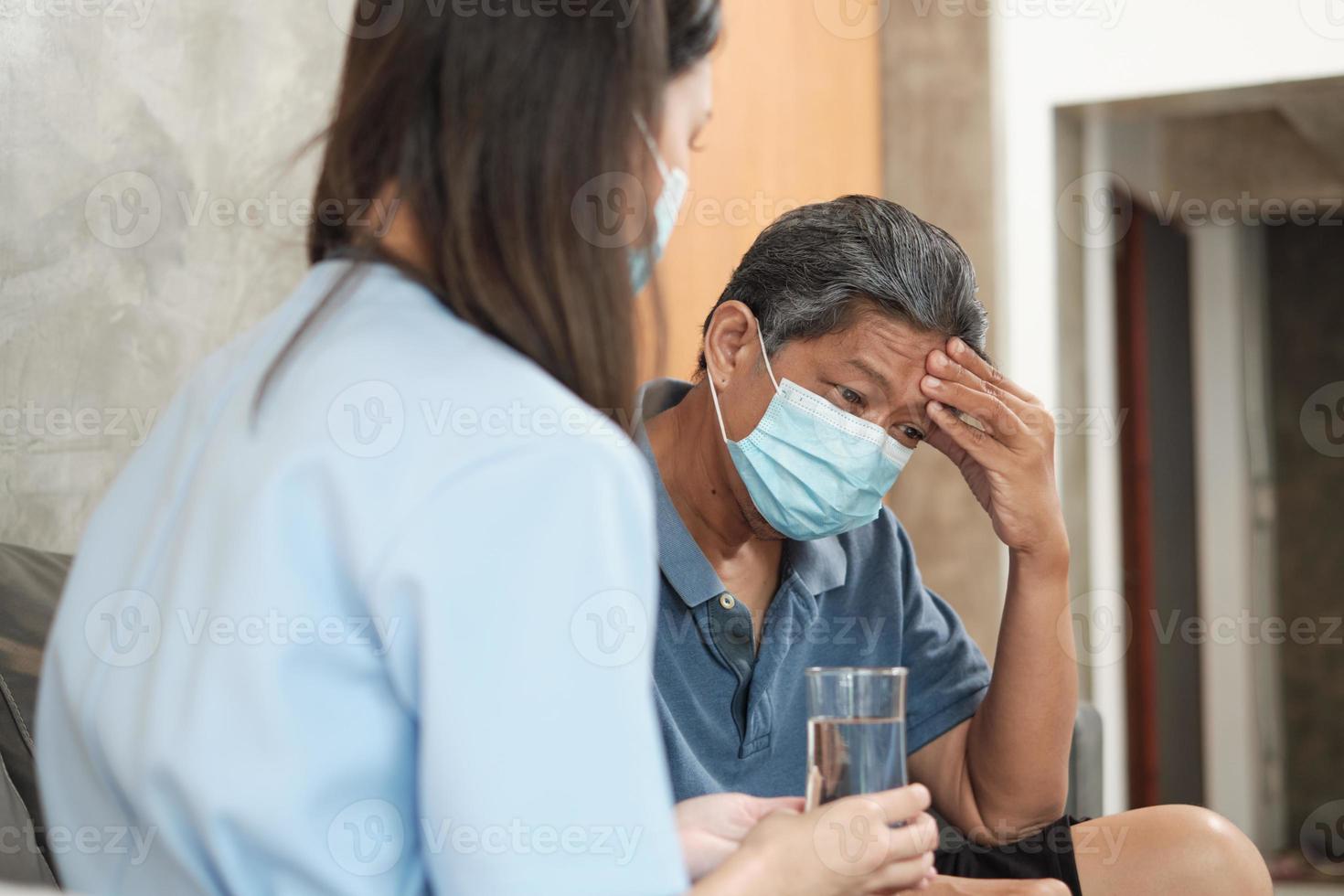 Doctor with drinking glass, help patient takes medicine. photo