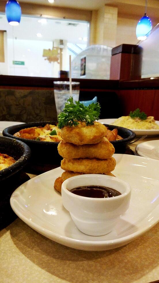 Deliciosos nuggets de pollo y salsa barbacoa en fondos de restaurante foto