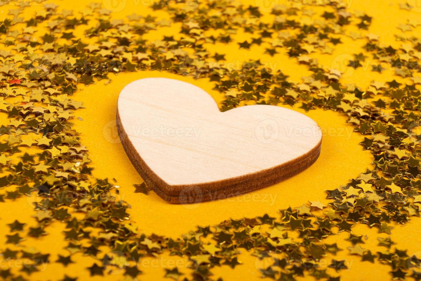amor símbolo corazón de madera sobre fondo amarillo, día de san valentín, día de la madre. foto