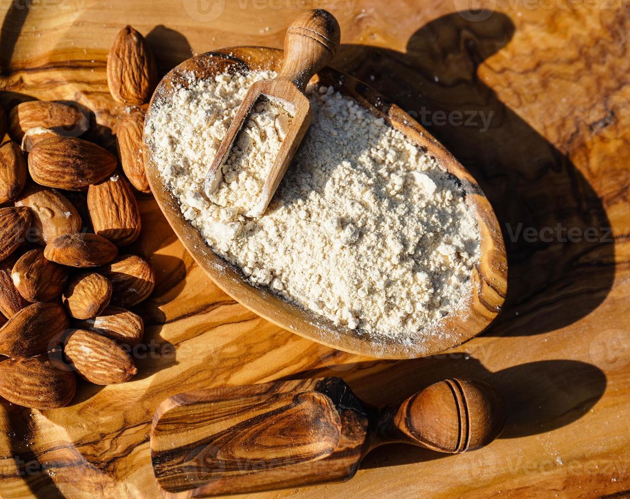 un montón de almendras peladas en madera de olivo foto