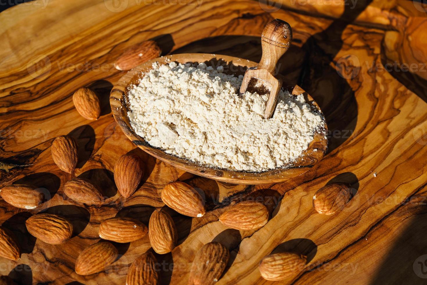 A pile of shelled almonds on olive wood photo