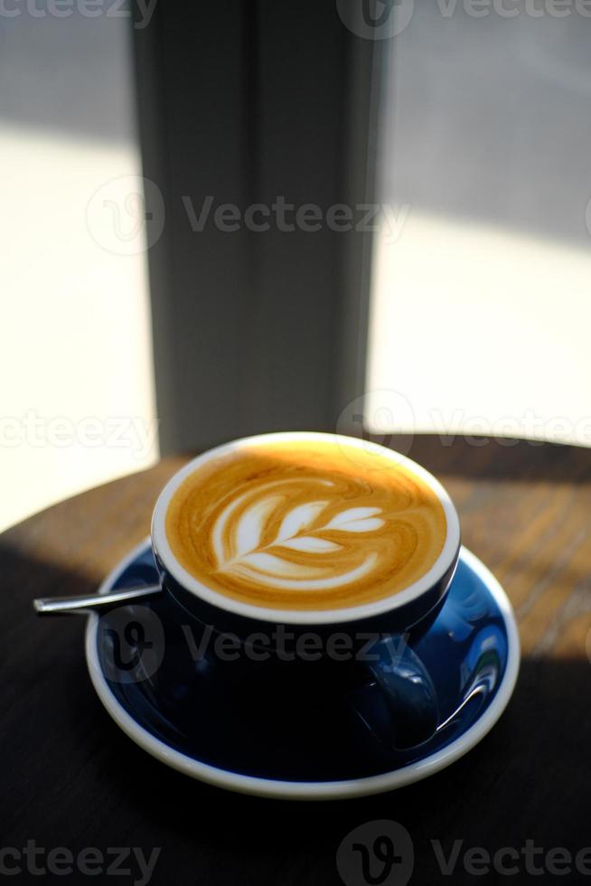 Impresionante latte art bebida de café caliente en la mesa de madera en la cafetería cafetería foto