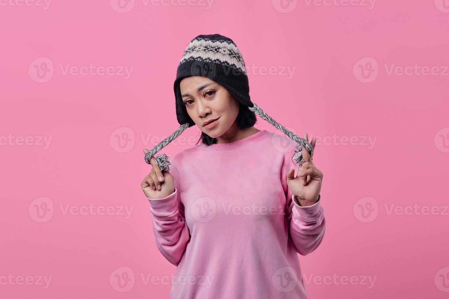 Portrait of angry woman standing looking at camera on pink background photo