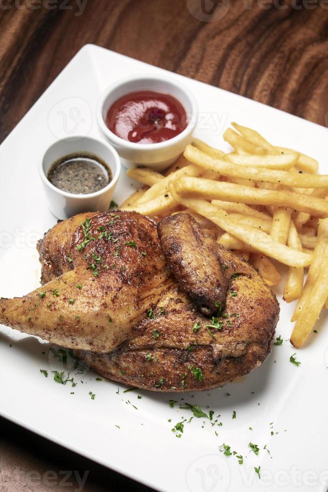 Roast rotisserie half chicken with french fries simple meal on white plate photo