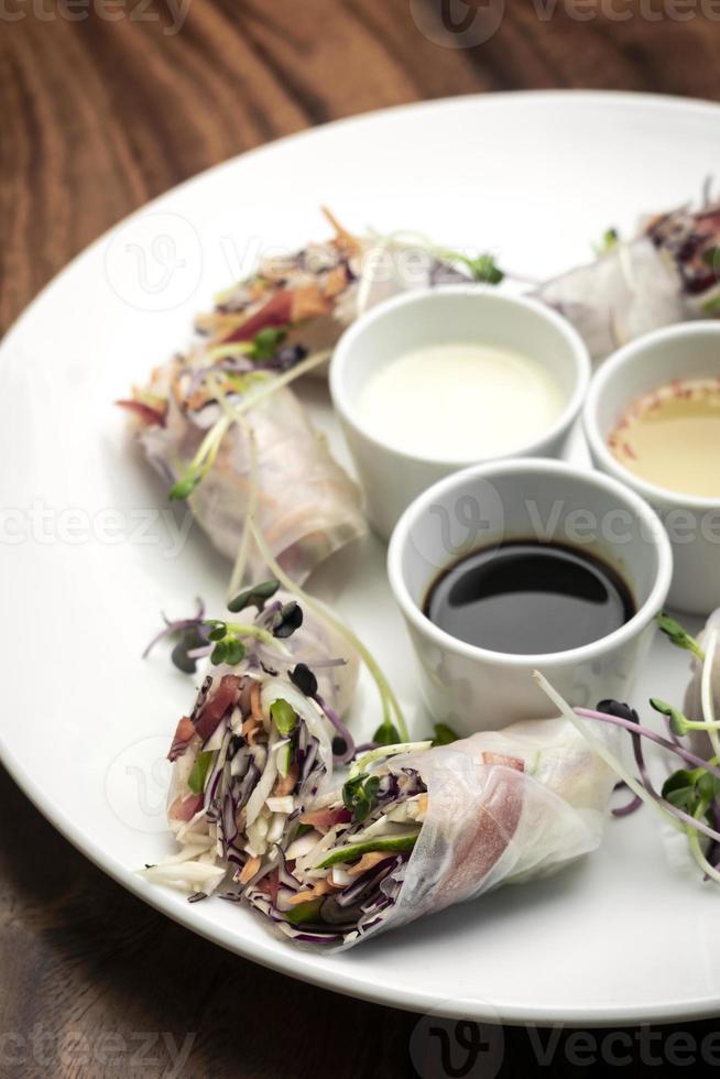 Asian fresh vegetable vegan spring rolls with sauces in Vietnam photo