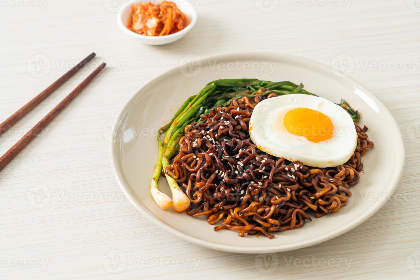 Korean spicy black sauce instant noodles with fried egg and kimchi photo