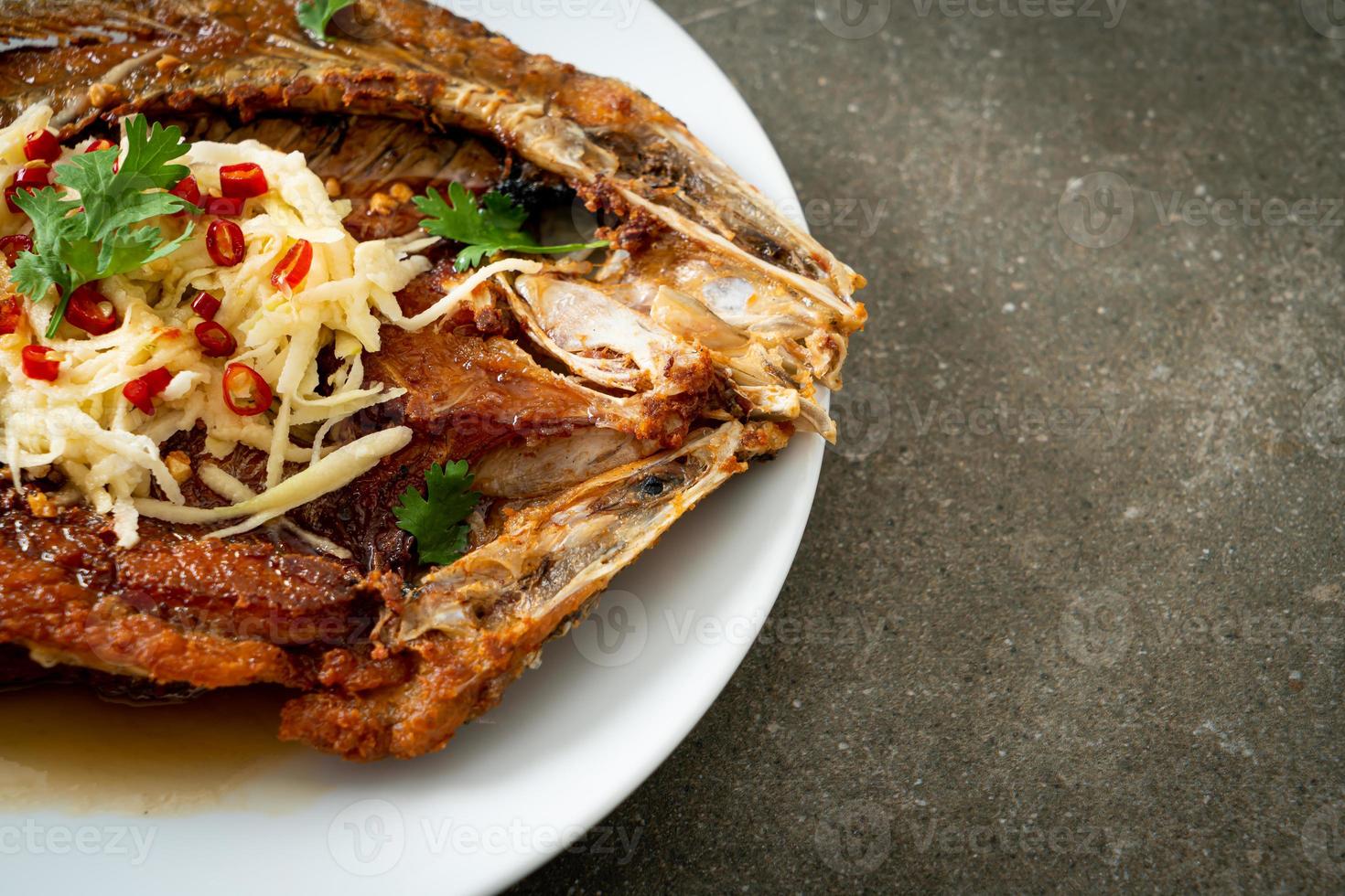 Lubina frita con salsa de pescado y ensalada picante foto