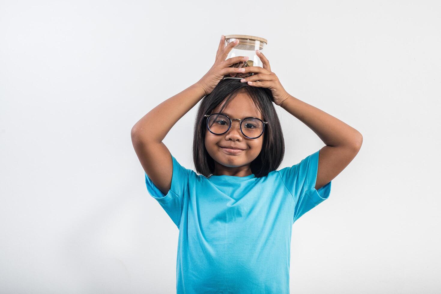 Portrait of little girl with her savings in studio shot. photo