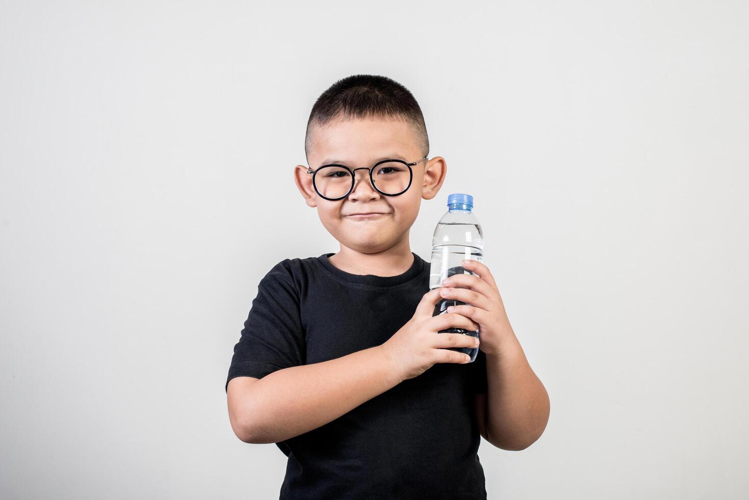 chico divertido con botella de agua en foto de estudio.