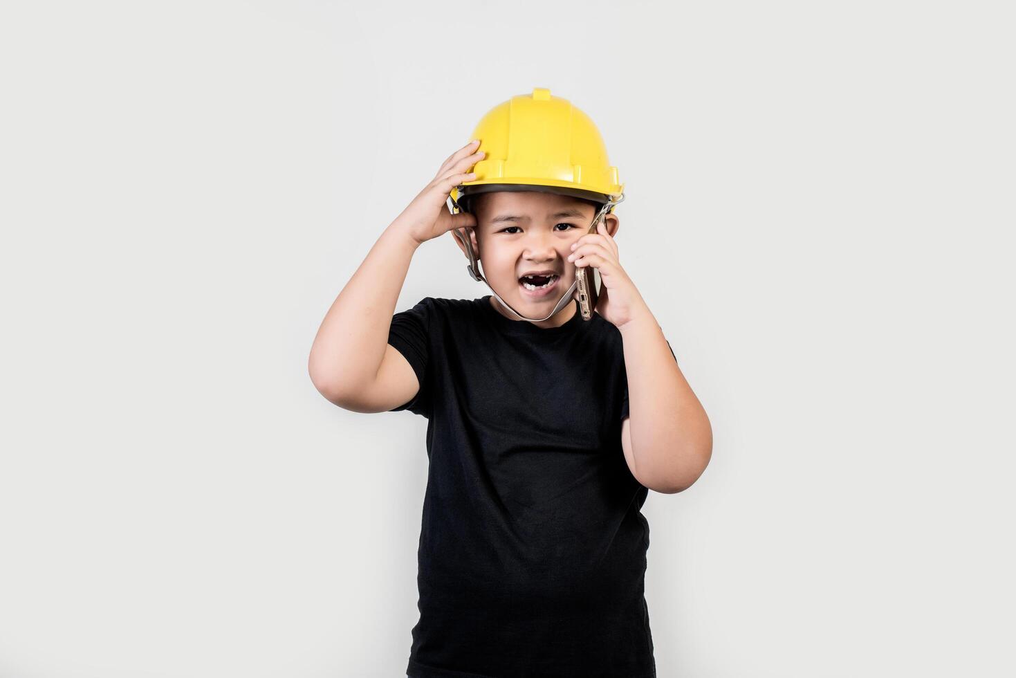 niño ingeniero hablando de teléfono inteligente sobre el proyecto con el socio. foto