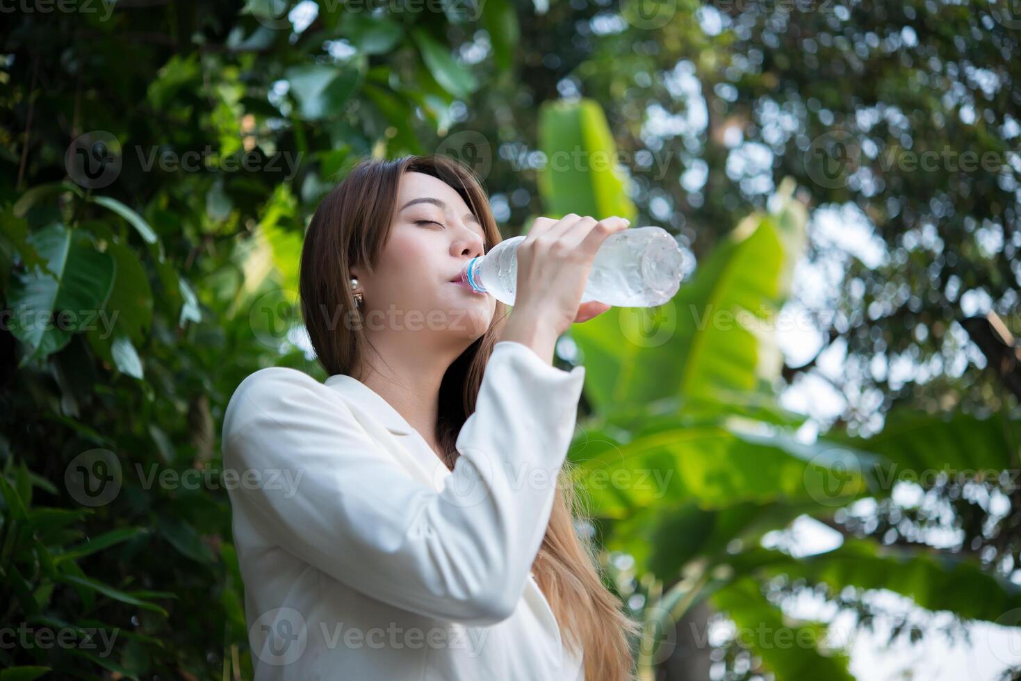 Hermosa mujer de negocios bebiendo agua después del trabajo duro foto