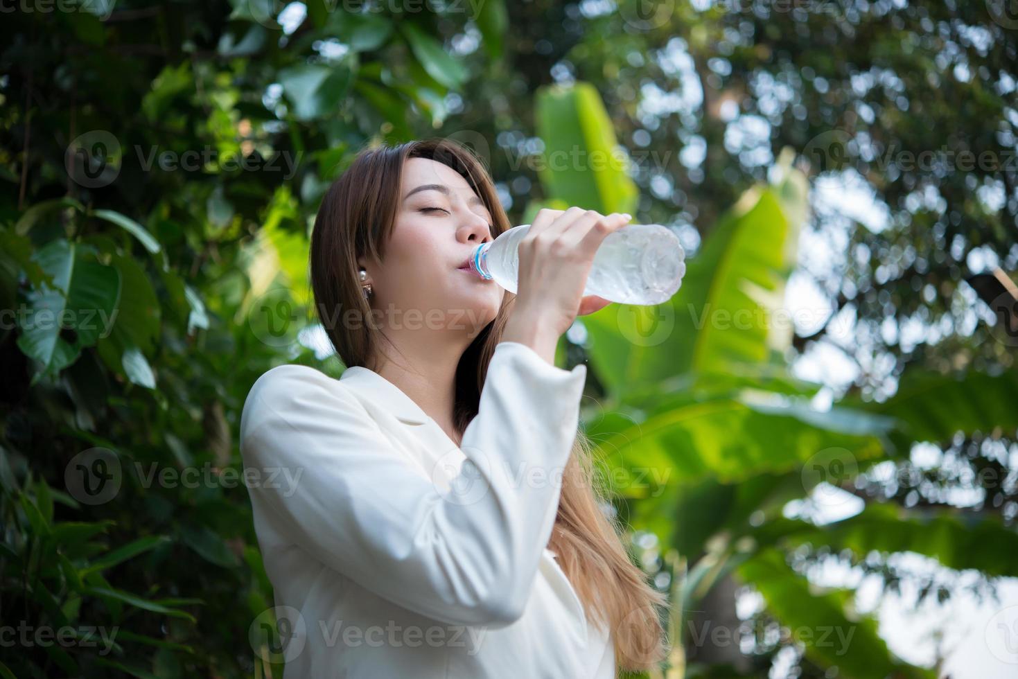 Hermosa mujer de negocios bebiendo agua después del trabajo duro foto
