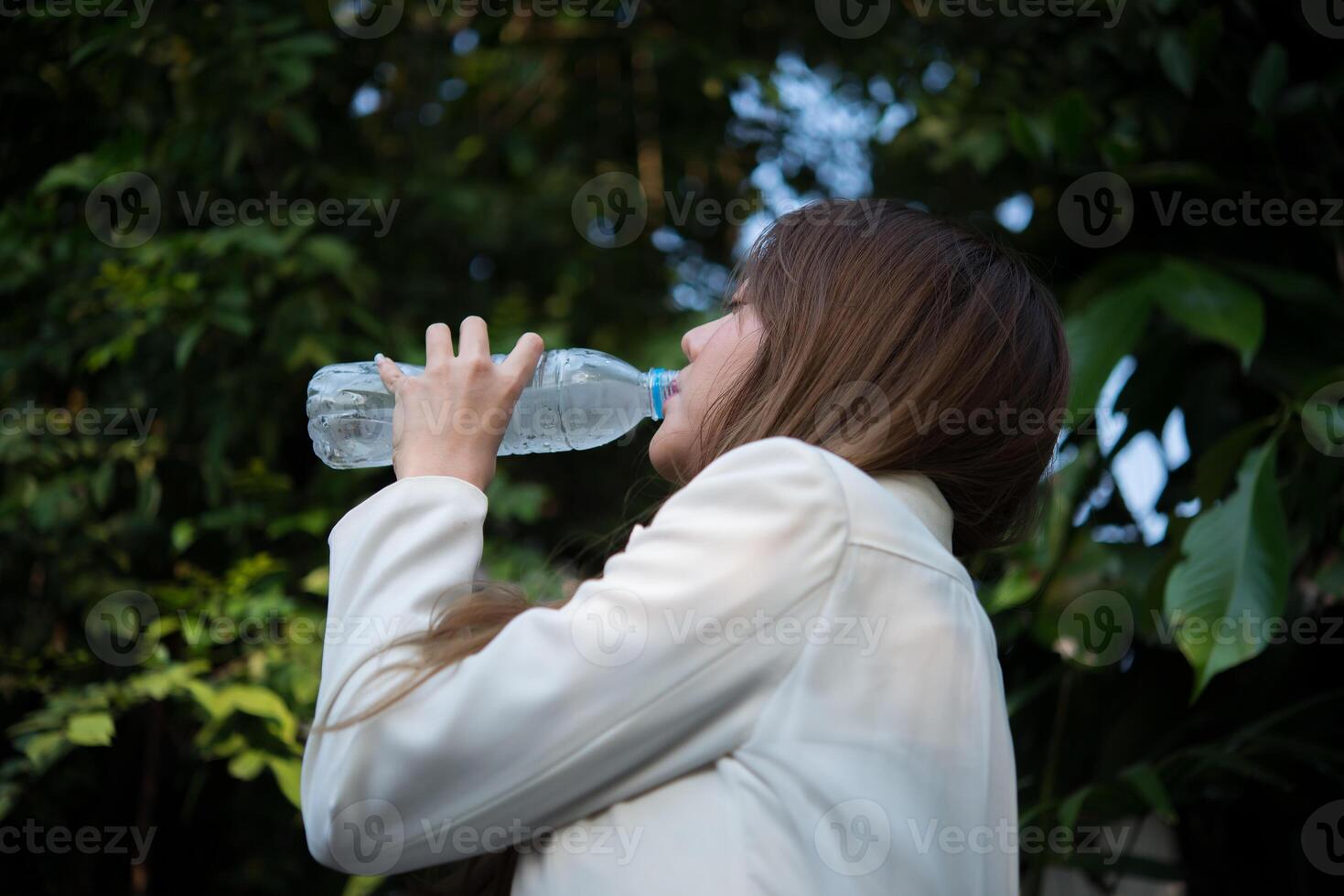 Hermosa mujer de negocios bebiendo agua después del trabajo duro foto