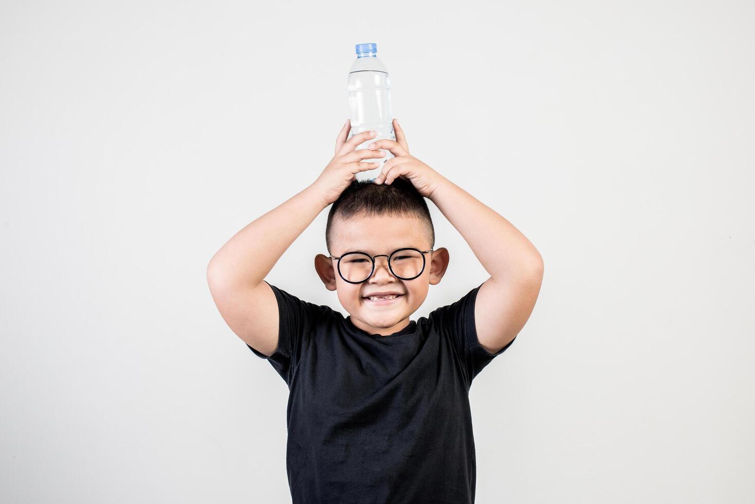 Chico divertido con botella de agua en foto de estudio