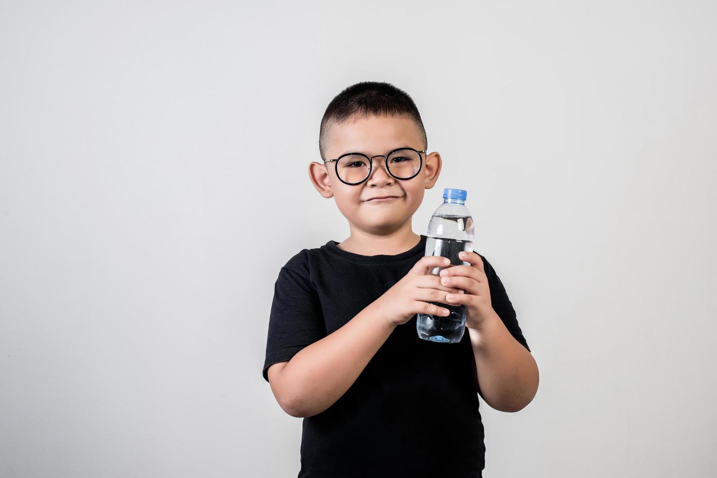 Funny boy with water bottle in studio shot photo