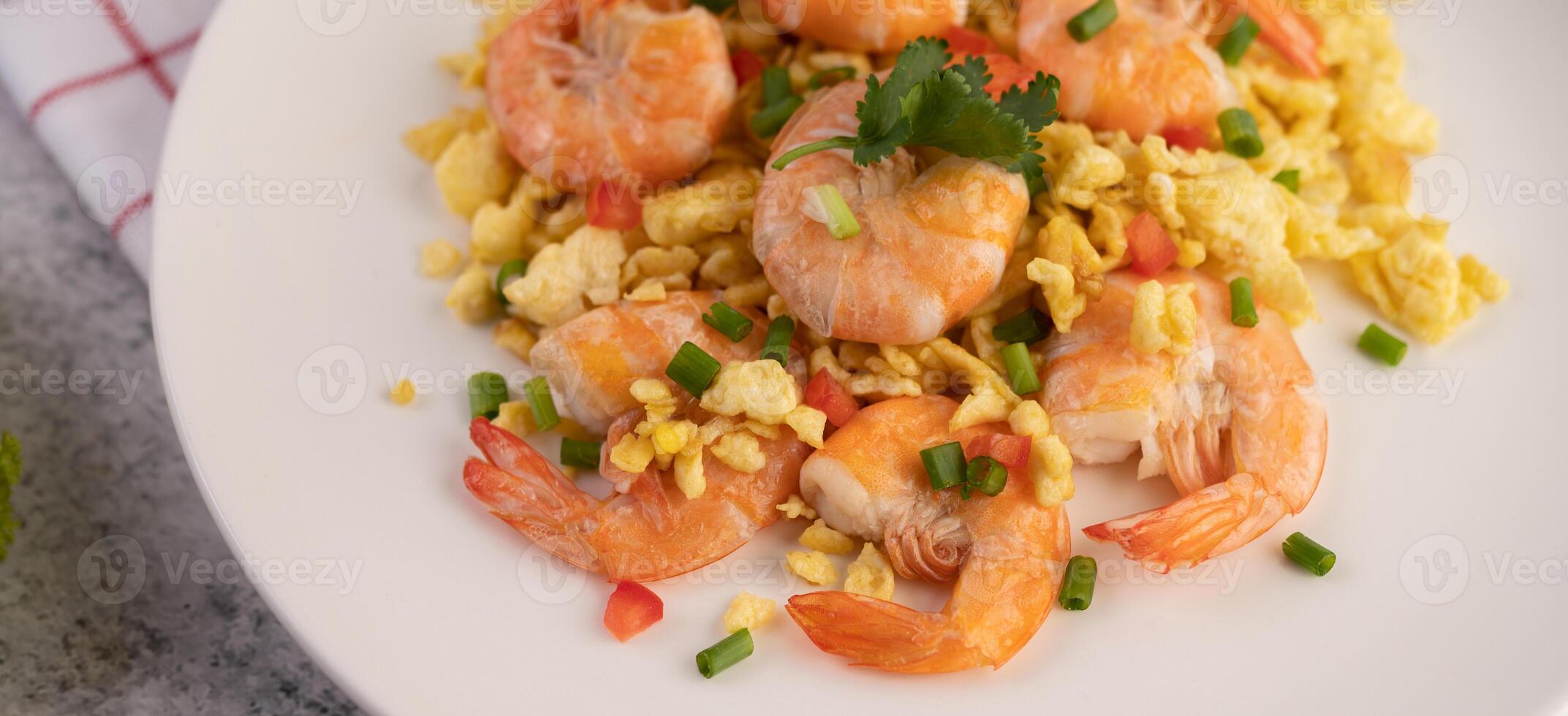 Stir fried eggs with shrimp on a white plate. photo