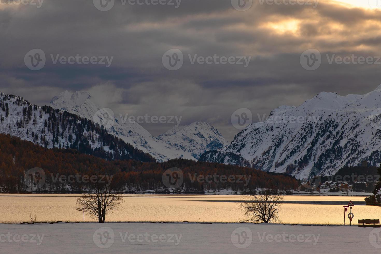 Otoño paisaje de montaña en un lago en el valle de la Engadina en el crepúsculo foto