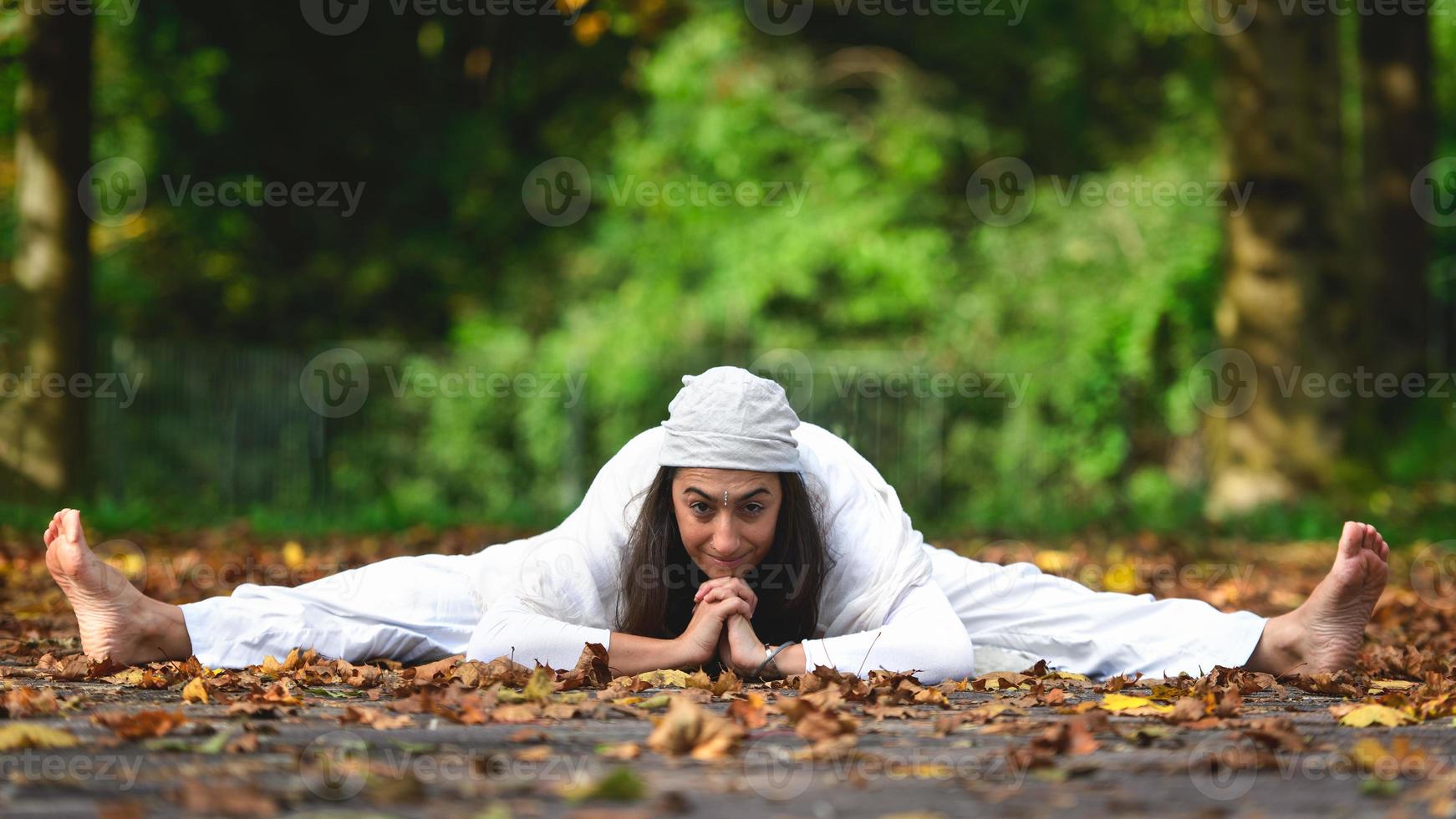 postura de yoga en el suelo en las hojas de otoño foto