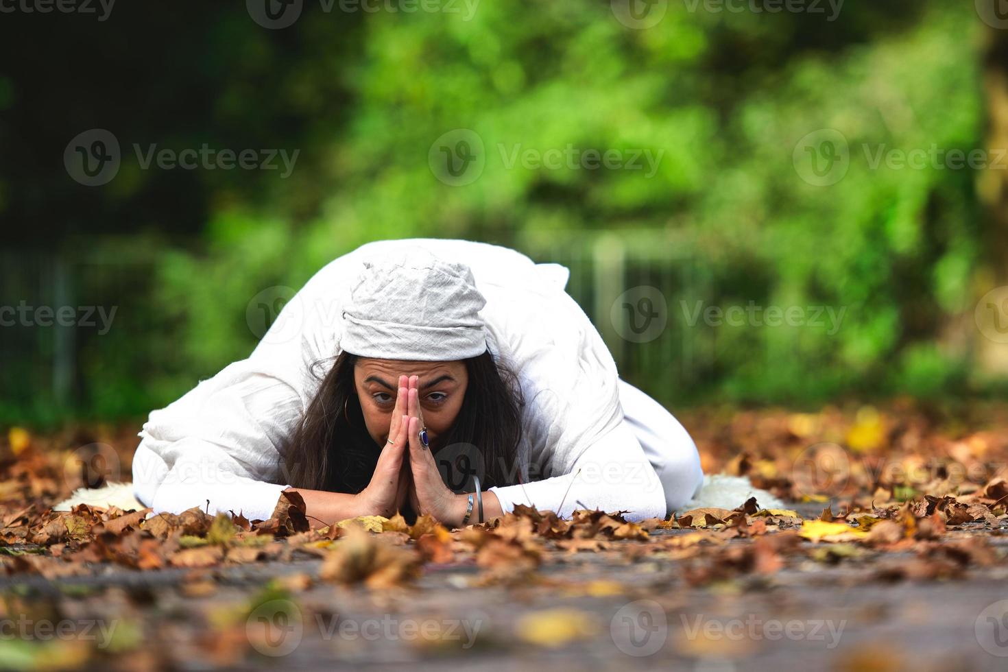 posición de yoga entre las hojas de otoño en el parque foto