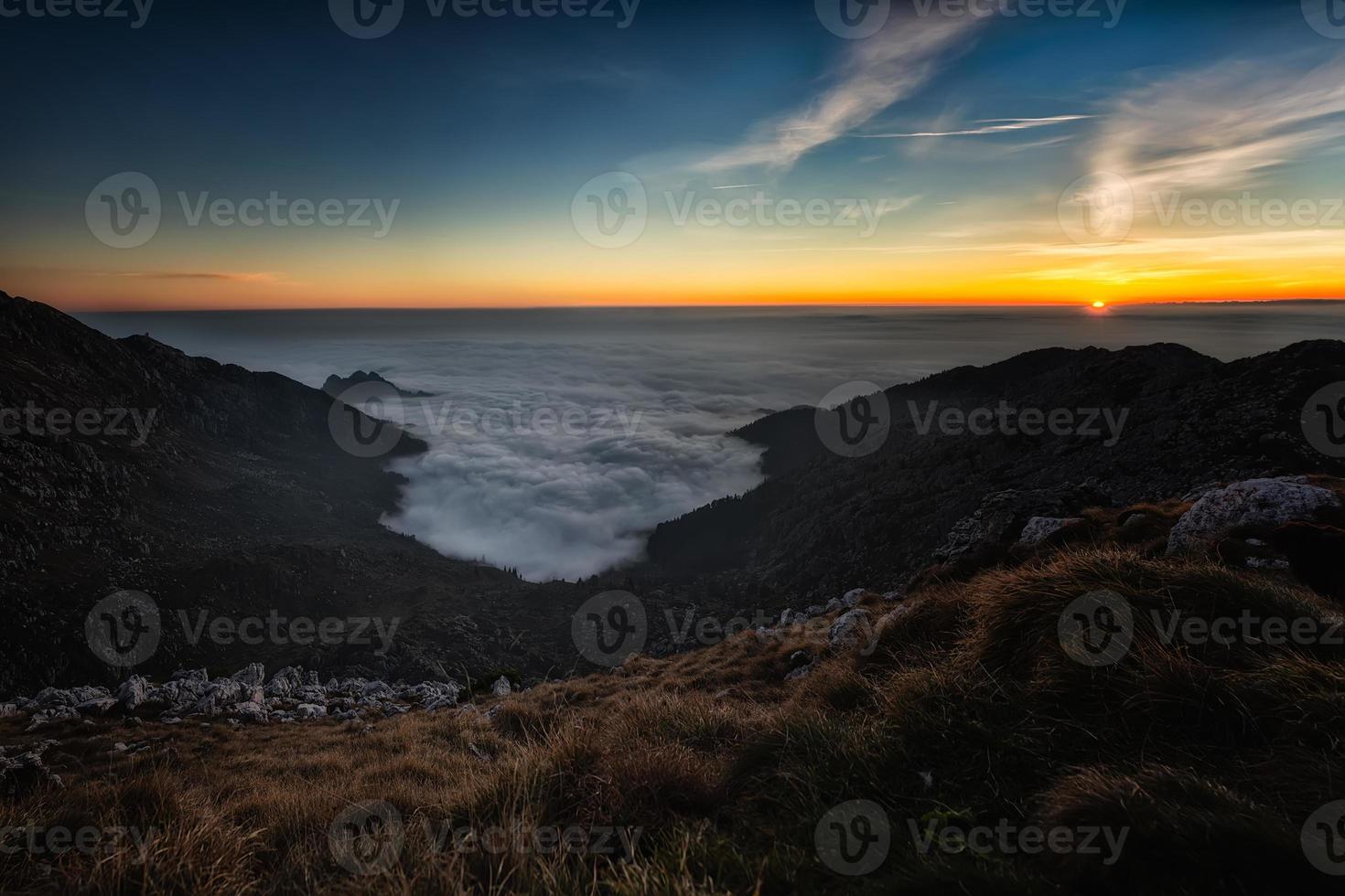 puesta de sol en las montañas con el mar de nubes bajas foto