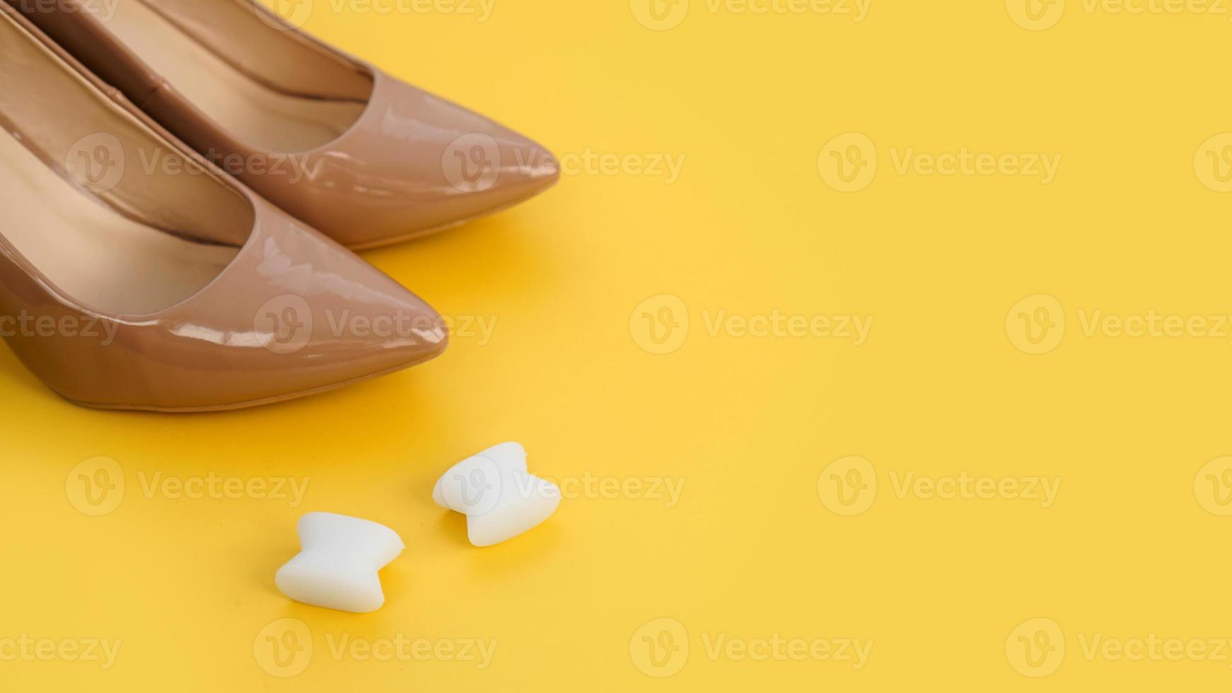 Foot silicone toe separator and beige shoes. Valgus on female feet photo